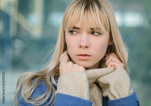 Portrait of young woman wearing blue coat.