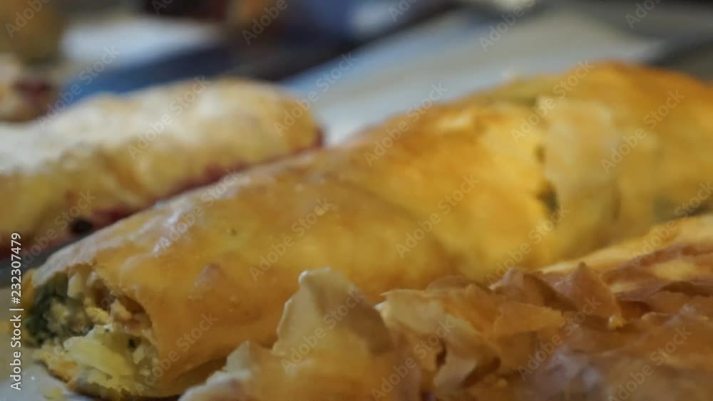 Close-up on meat strudels and sweet strudels lying on a baking sheet in a restaurant Close-up on meat strudels and sweet strudels lying on a baking sheet in a restaurant
