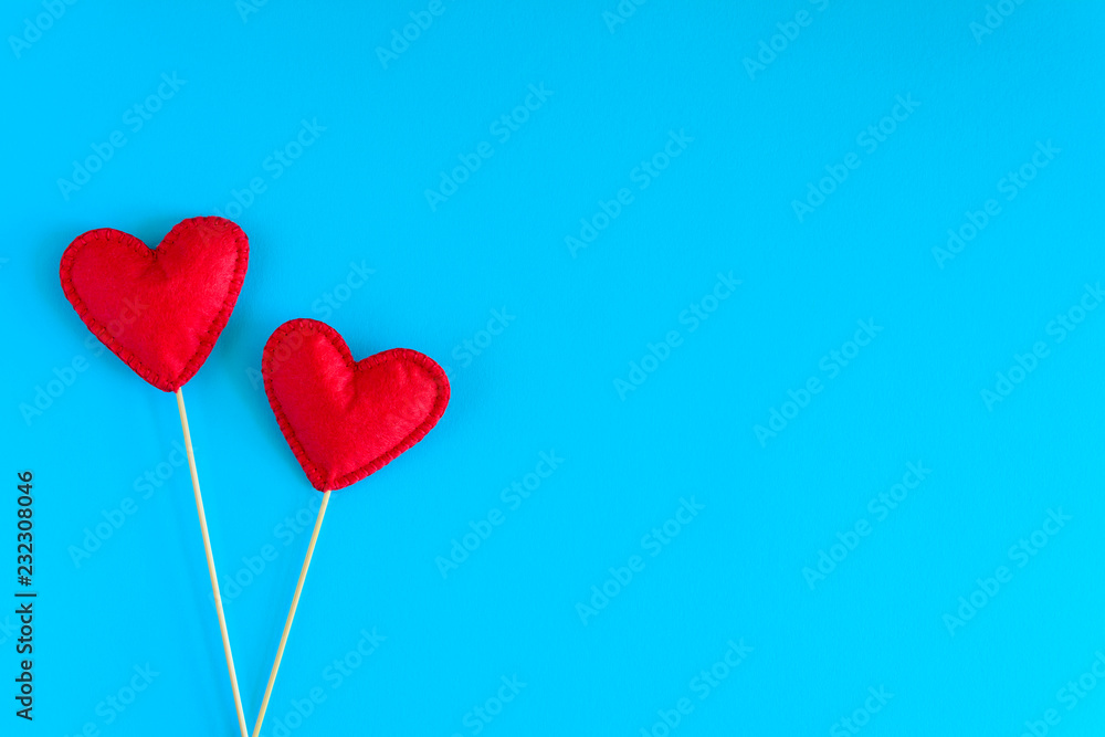 Felt love hearts on booth props on blue paper background. Valentine's day celebration concept. Top view. Flat lay