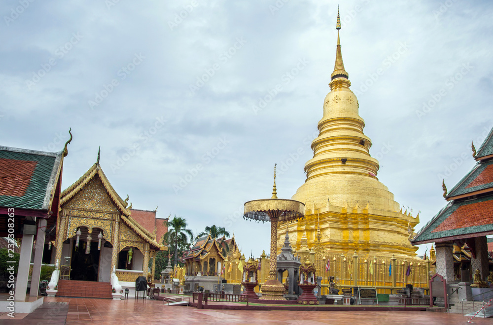 Naklejka premium Golden Pagoda at Phra That Hariphunchai Temple (Wat Phra That Hariphunchai) in Lamphun, north of Thailand