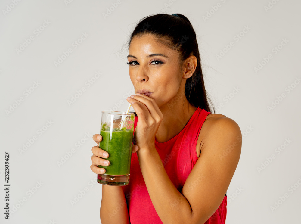 Happy beautiful fit sport woman smiling and drinking healthy fresh vegetable smoothie Happy beautiful fit sport woman smiling and drinking healthy fresh vegetable smoothie