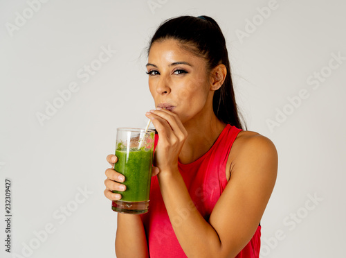 Happy beautiful fit sport woman smiling and drinking healthy fresh vegetable smoothie