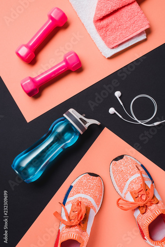 Fototapeta Naklejka Na Ścianę i Meble -  Flat lay with sneakers, dumbbells, sport bottle, towel and headphones on black background