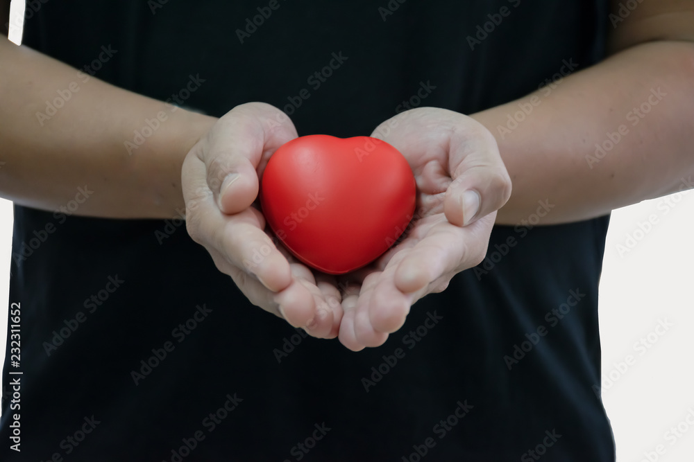 Man in black t-shirt holding red heart in his hand, copy space for text and isolated on white background Man in black t-shirt holding red heart in his hand, copy space for text and isolated on white background