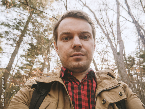 Young man makes selfie in the forest.