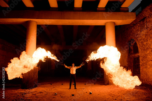 Halloween man in costume with flamethrower in his hands. Devil makeup on face photo