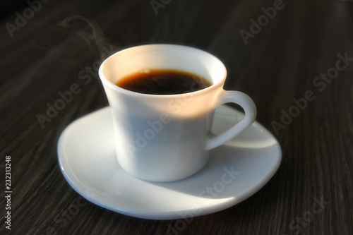 Black hot coffee with sunlight on table