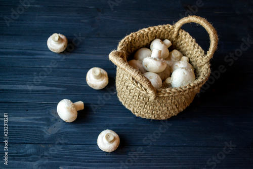 The champignons in a basket on a wooden table.