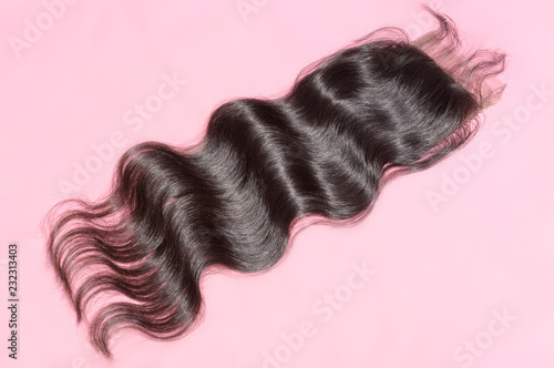 Body wavy black human hair weaves extensions lace closure upon pink background