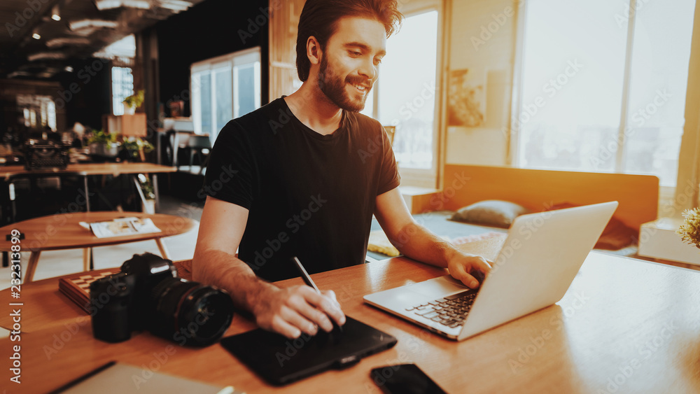 Smiling Graphic Designer Works on Laptop Indoors Smiling Graphic Designer Works on Laptop Indoors