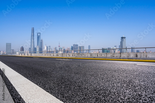 empty asphalt road with city skyline