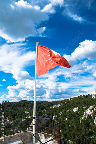 The red flag of the medieval village of Les-Baux-de-Provence in the Alpilles regional park, France