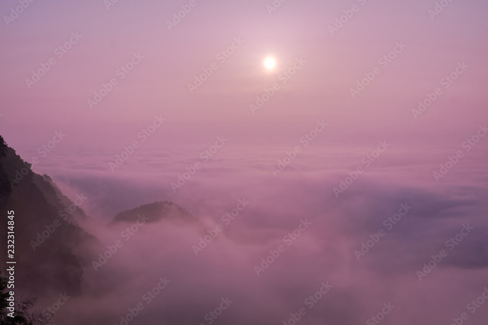 Purple sunrise in clouds in mountain