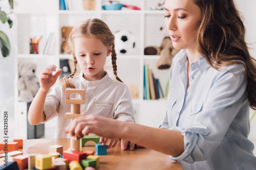 mother playing wooden blocks with little daughter mother playing wooden blocks with little daughter