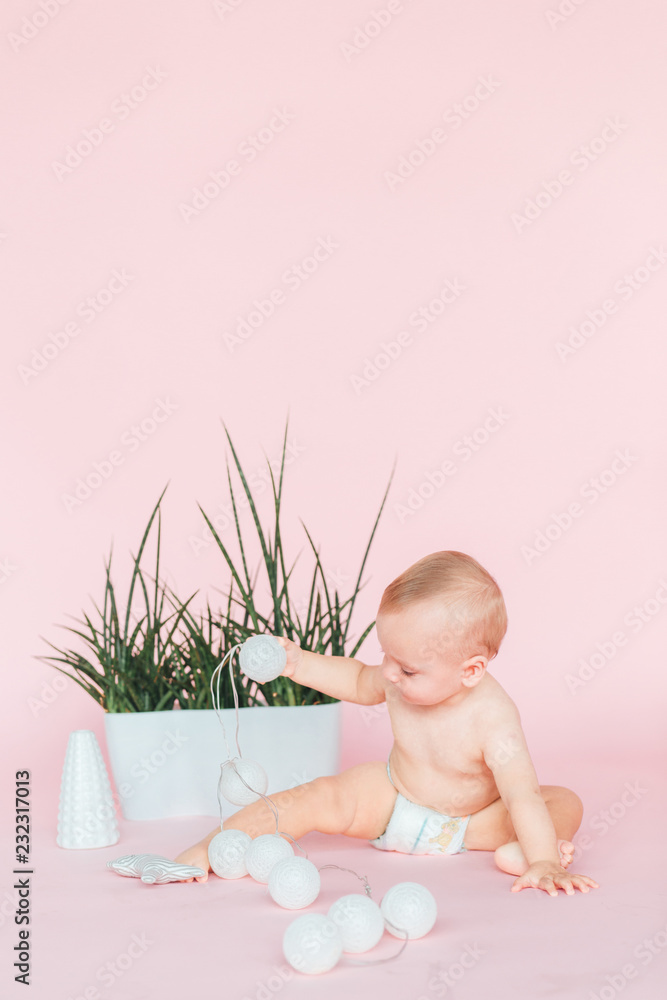Happy Baby. Image of sweet baby boy, closeup portrait of child, cute toddler. Children, people, infancy and age concept. Infant child baby in diaper lying happy smiling on a pink background