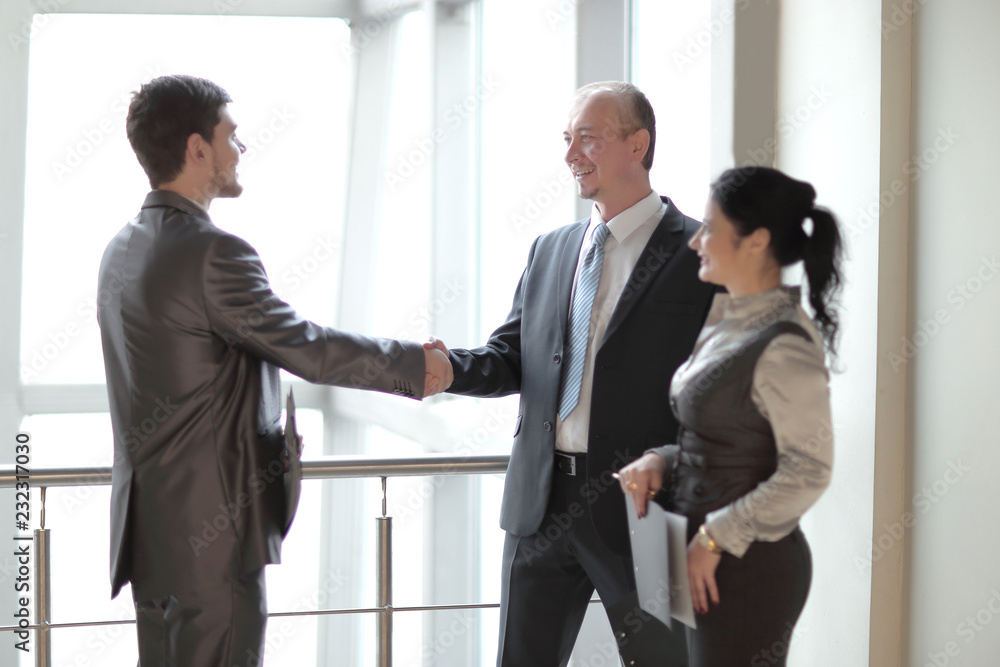 smiling business team looking at a financial chart smiling business team looking at a financial chart