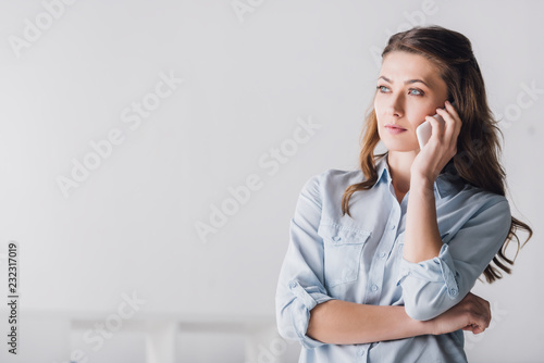 serious adult woman talking by phone and looking away