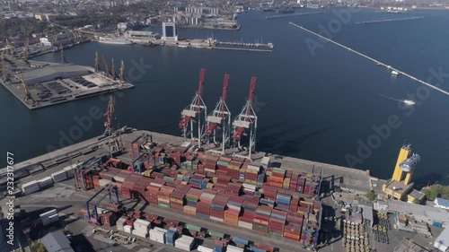 ODESSA, UKRAINE - OCTOBER 17, 2018: drone view of trading port industry with containers and lifting cranes for loading and unloading of vessel on Black Sea quayside