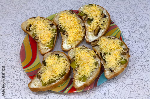 Six sandwiches lying on a plate made from bread meal of cheese and cucumbers. The National dish.
