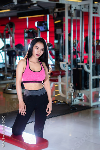 Fitness Asian women Stand in sport gym interior and fitness health club with sports exercise equipment Gym background.