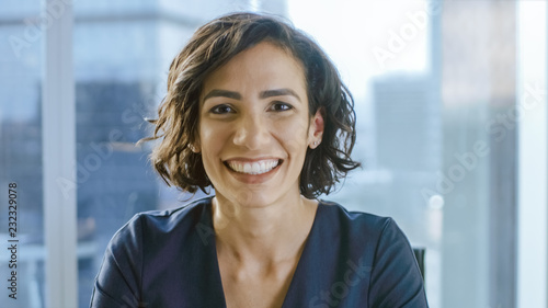 Portrait of a Beautiful Hispanic Woman Smiling Charmingly. Out of Focus Cityscape Background.