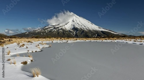 Breathtaking view of Mount Taranaki, enormous volcano in New Zealand on winter day in timelapse video.