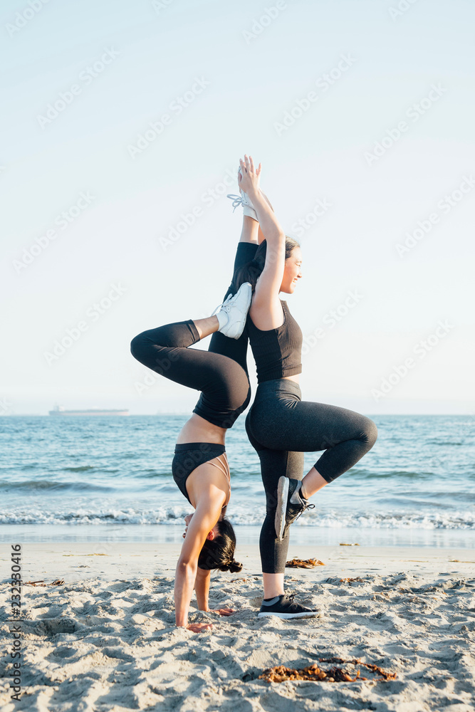 Friends doing exercises on beach Friends doing exercises on beach