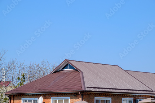 Metal roof brown. Construction of houses and types of roofing