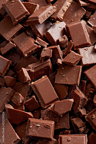 Chocolate background. Chocolate chunks and pieces on a pile. Top view. Full frame