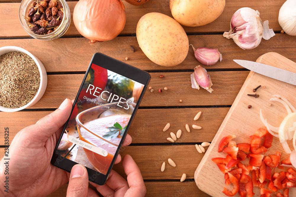 Using digital cookbook app in smartphone for cooking - obrazy, fototapety, plakaty 