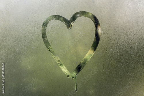 Heart on the misted glass.