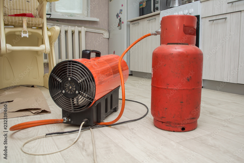 repairmen install stretch ceiling made of pvc vinyl film using a gas