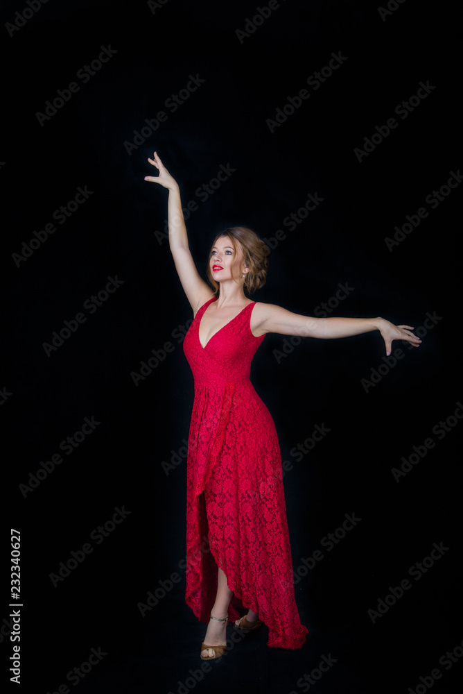beautiful female dancer in red dress with arms outstretched on black background beautiful female dancer in red dress with arms outstretched on black background