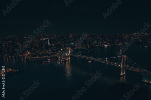 Aerial drone photo - Rainbow Bridge and the skyline of Tokyo at night. Capital city of Japan. 