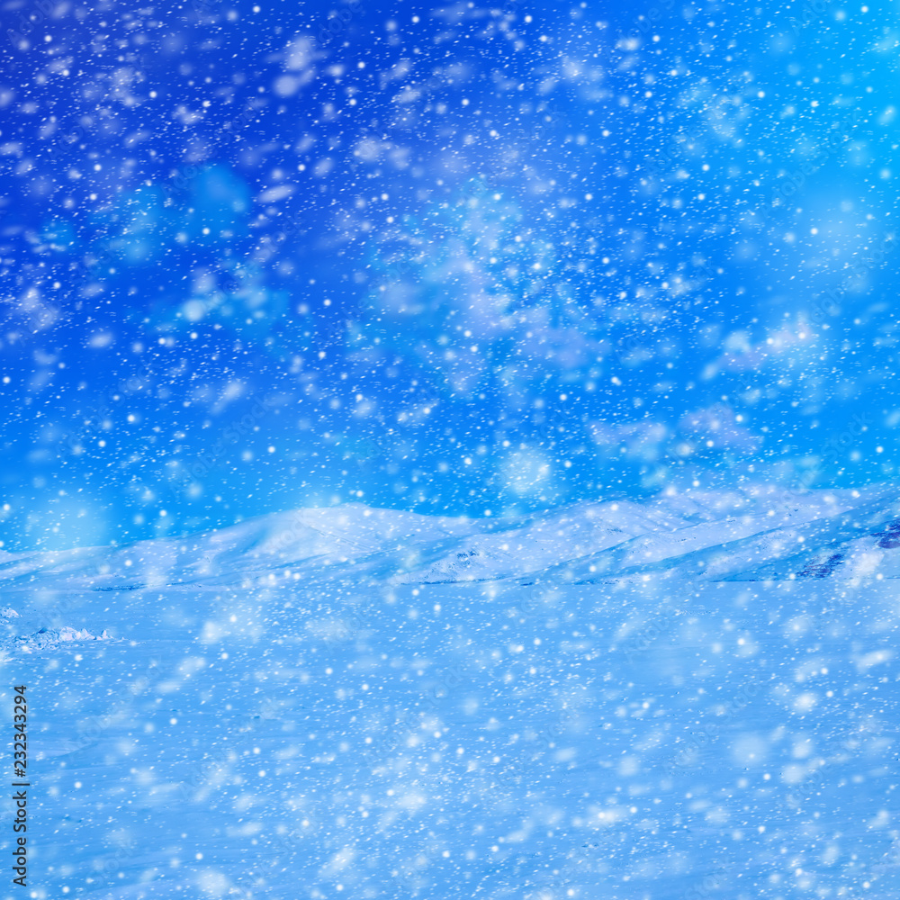 Snow covered empty frozen landscape of mountainside over blue sky with clouds Snow covered empty frozen landscape of mountainside over blue sky with clouds