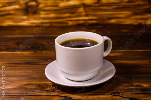 Cup of dark coffee on wooden table