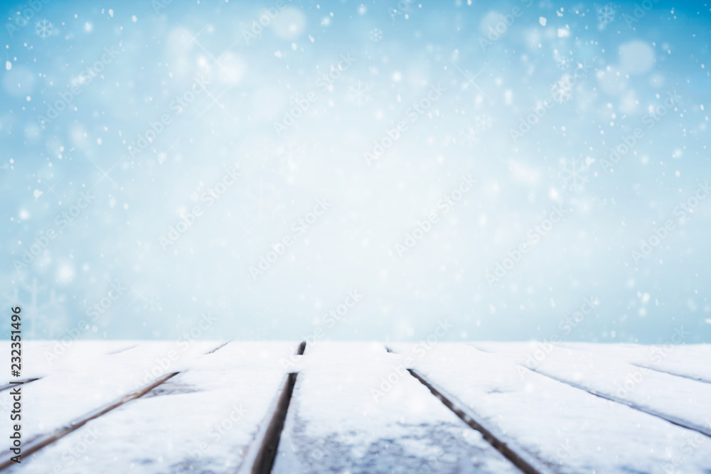 Winter background, falling snow over wooden deck 