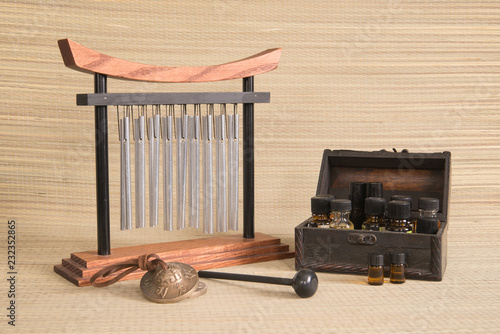 Schilderij op canvas Spa concept with tabletop tranquility chimes and essential oils on a woven mat background