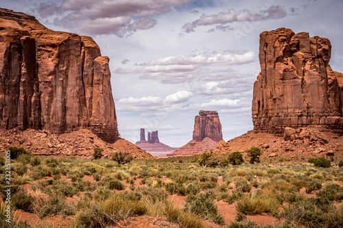 Giant red rock formations rise above the valley on a cloudy day in Monument Valley, along the Arizona and Utah border, Four Corners region