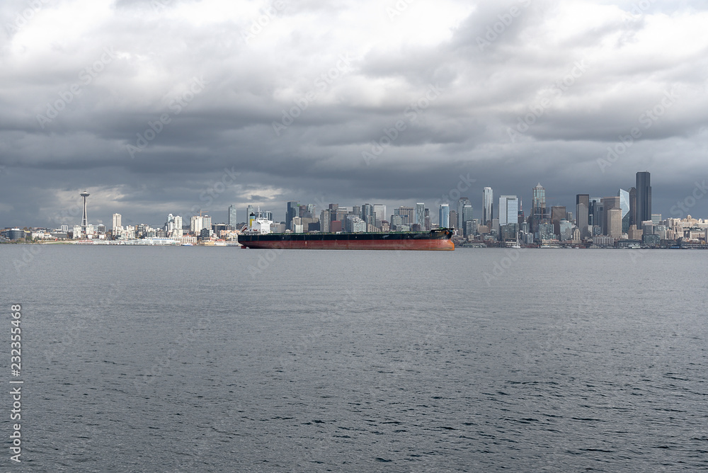 Seattle skyline across Elliott bay under gray cloud sky