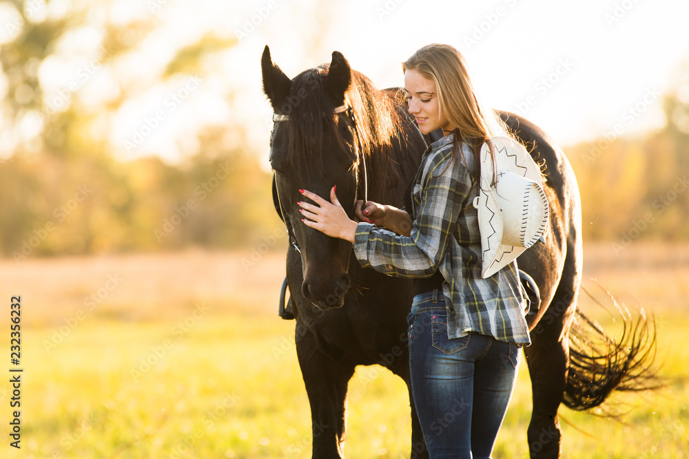 Girl horse rider stands near the horse and hugs the horse. Horse theme 