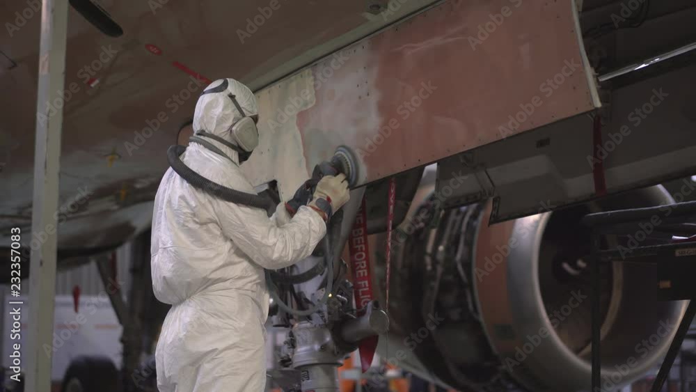 Painting the aircraft at the factory. The engineer repairing the aircraft. Maintenance of passenger aircraft. Repair of an aircraft wing. Passenger plane in the hangar in the repair. 4K Painting the aircraft at the factory. The engineer repairing the aircraft. Maintenance of passenger aircraft. Repair of an aircraft wing. Passenger plane in the hangar in the repair. 4K