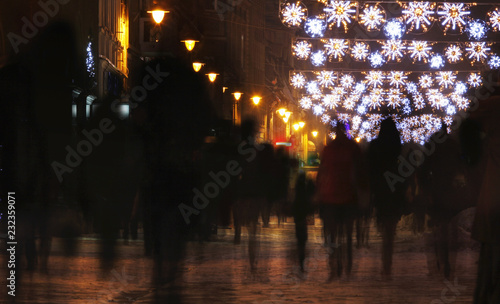 Christmas city streets full of colorful decorative lights and crowded with pe