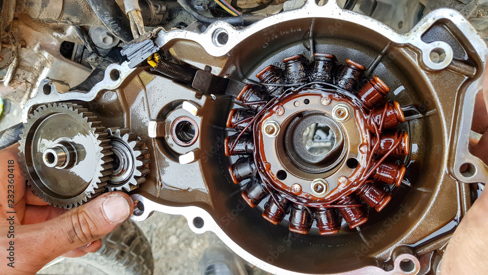 Broken alternator from motorcycle engine in hands from oil Stock Photo |  Adobe Stock