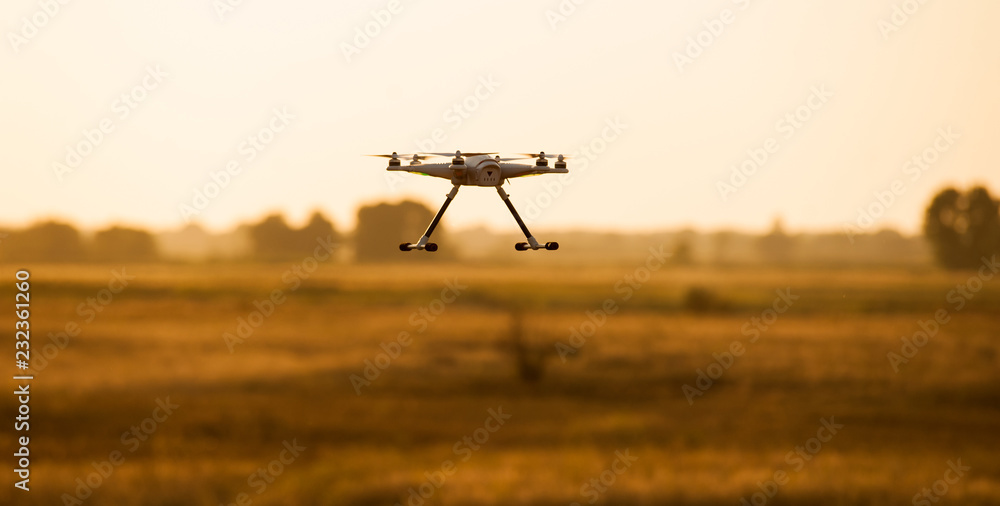 Flying drone in flight over a beautiful meadow Flying drone in flight over a beautiful meadow