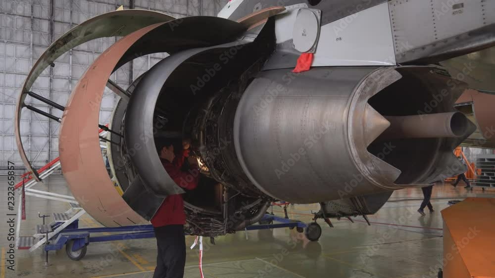 Engineer, technician examines the jet engine with a flashlight. The repair of aircraft in the hangar. Maintenance of aircraft. 4k Engineer, technician examines the jet engine with a flashlight. The repair of aircraft in the hangar. Maintenance of aircraft. 4k