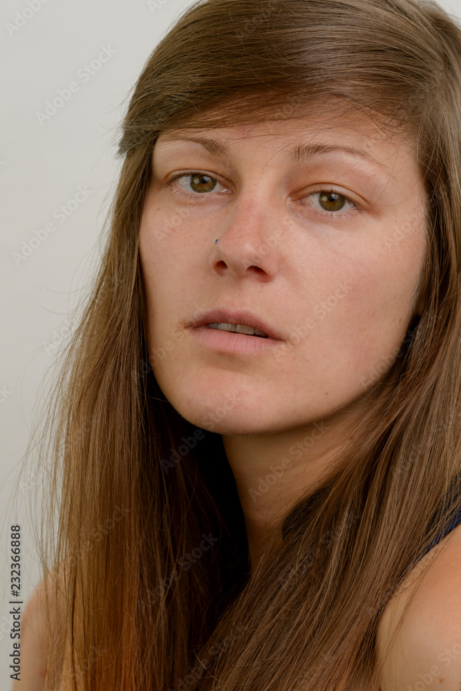 Beautiful young woman without makeup. Natural beauty concept. Young female with unruly hair on gray background. Beautiful young woman without makeup. Natural beauty concept. Young female with unruly hair on gray background.