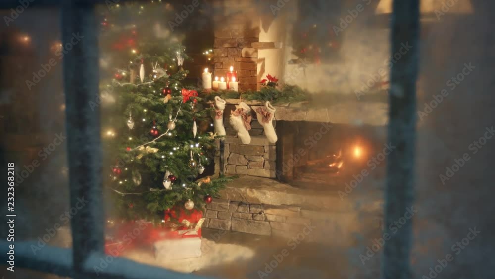 Christmas tree scene through frozen window. Traditional scene with presents under the tree and fire in fireplace. Decorated living room and candle light and socks with presents on fireplace sims.