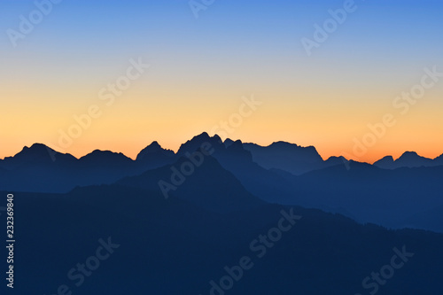 Wallpaper Mural Beautiful morning mood in the Allgaeu Alps at the border region of Germany and Austria. Blue silhouettes of mountain ranges at dawn with orange and blue sky. Zugspitze in the background. Copy space. Torontodigital.ca