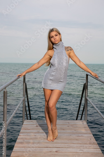 Young woman posing on the pier at the lake